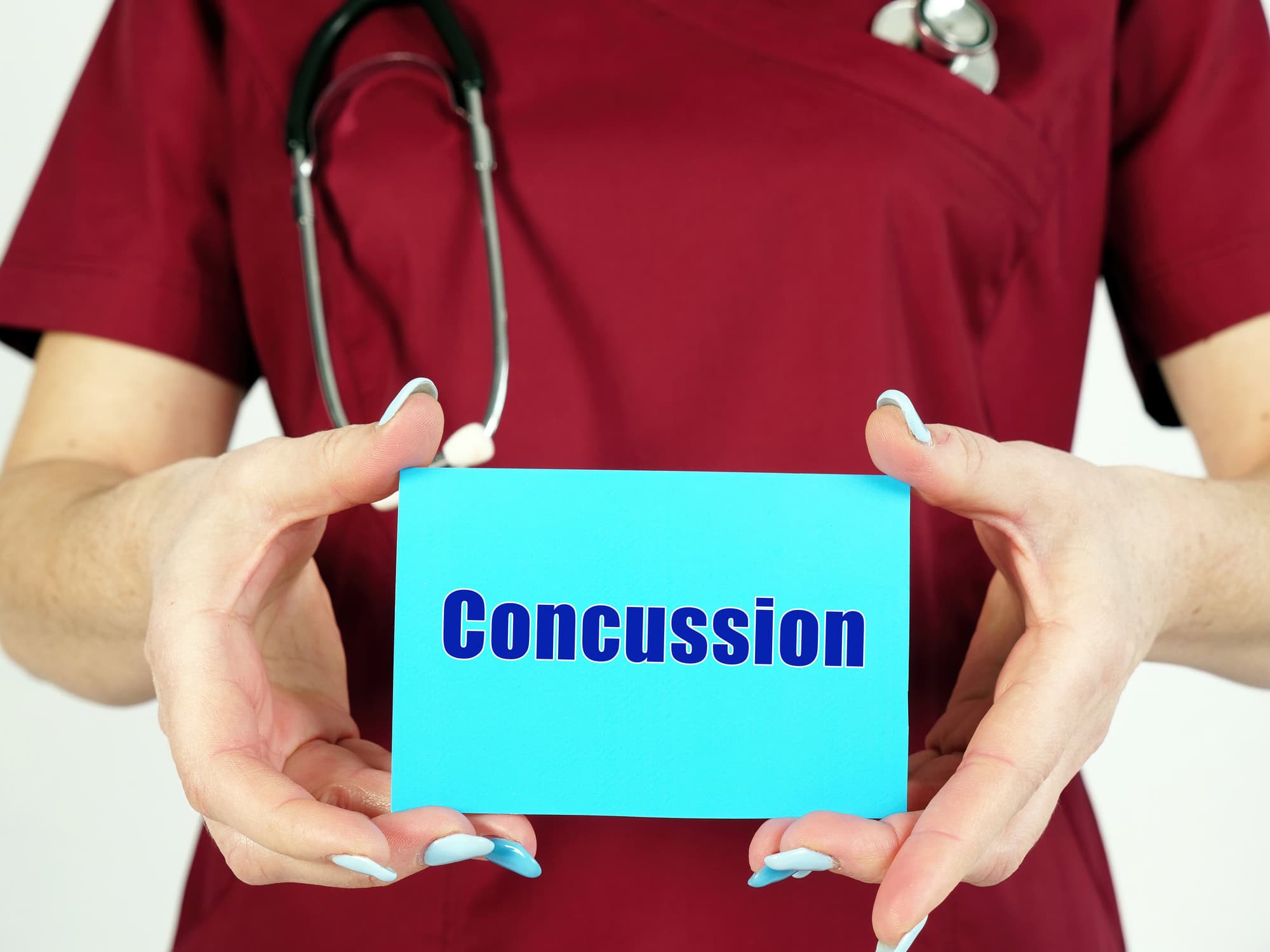 physician holding a card that reads Concussion